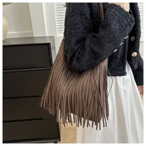 Macro detail of dark brown bohemian fringe shoulder bag with premium suede texture