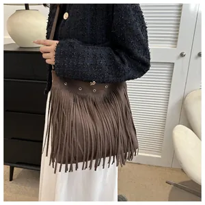 Close-up detail of a brown fringe shoulder bag with high-quality suede texture and metal eyelets
