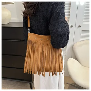 Detail of brown fringe suede shoulder bag showing tassel texture and metal eyelets