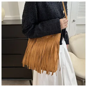 Close-up of brown suede fringe shoulder bag showing boho tassels and matte texture detail