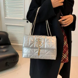 Sac bandoulière argenté matelassé avec chaîne dorée et élégant détail de pompon