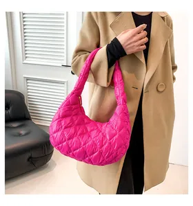 Detail of bright pink quilted puffer bag with classic diamond stitching and hobo design
