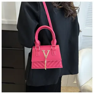 Dettagli della borsa a tracolla trapuntata rosso rosa con logo V dorato e nappina