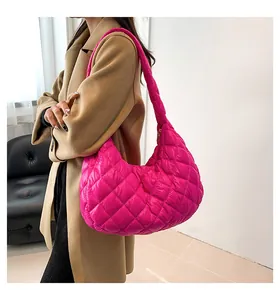 Close-up of rose red quilted puffer hobo bag shoulder strap and zip closure texture