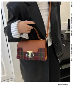 Detail of vintage plaid handbag with leather patchwork and gold metal twist lock
