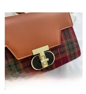 Close-up of golden T-shaped metal twist lock and multi-color plaid fabric texture
