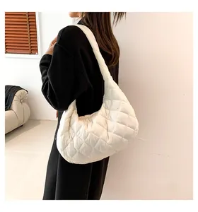 Close-up of white quilted puffer shoulder bag showing rhombus stitching texture and soft material