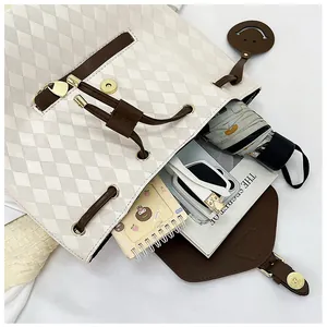 Intérieur spacieux d'un sac à dos beige matelassé montrant le rangement des accessoires