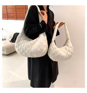 Detail of white quilted cloud bags in two sizes styled with a black coat