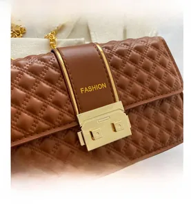 Détail de la texture en cuir matelassé marron avec boucle dorée et imprimé mode