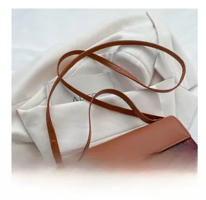 Detail of vintage plaid crossbody bag with brown leather trim and golden T-shaped lock