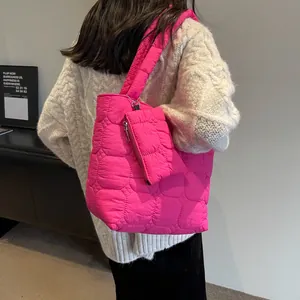 Dettaglio della borsa tote rosa acceso con motivi a cuore trapuntati e pochette abbinata