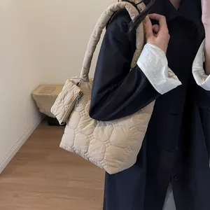Dettaglio della borsa a tracolla trapuntata beige con un piccolo borsellino abbinato