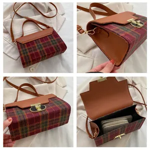 Detail view of vintage plaid crossbody bag with leather straps and golden clasp buckle