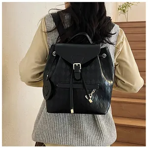 Détail d'un sac à dos noir matelassé avec cordon de serrage et chaîne décorative