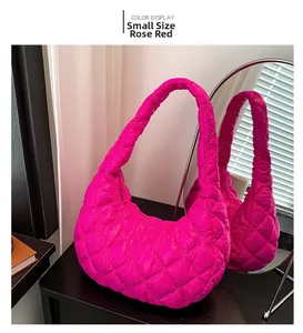 Detail view of small rose red quilted shoulder bag with cloud texture and metallic finish