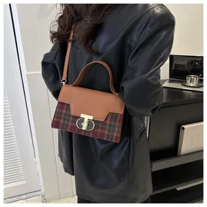 Model shot of a retro plaid handbag with a gold T-lock and synthetic leather details