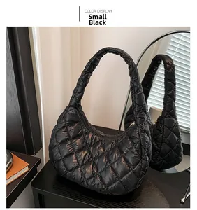 Detail of small black quilted cloud bag with glossy rhombus stitching and puffy texture