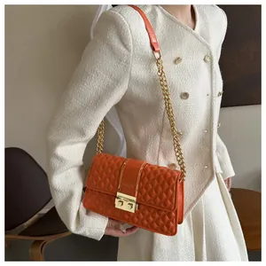 Détail du sac à bandoulière matelassé orange en similicuir avec chaîne dorée