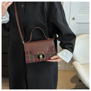 Retro plaid crossbody bag with gold T-shaped lock shown worn on model in white interior