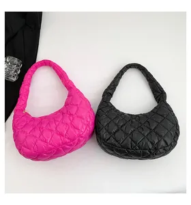Detail view of quilted puffer shoulder bags in vibrant rose pink and classic black colors