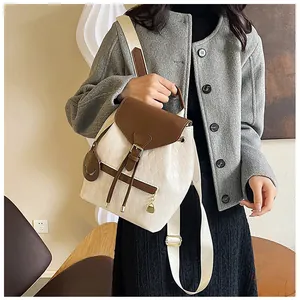 Détail du sac à dos quadrillé avec corps crème et rabat marron sur un mannequin