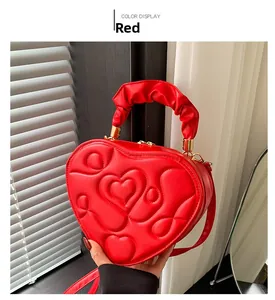 Detail der roten herzförmigen Handtasche mit Steppmuster und gerafftem Griff
