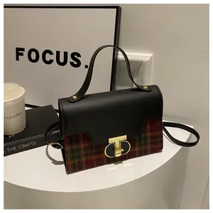 Detail view of vintage plaid handbag with premium leather patchwork and gold T-lock