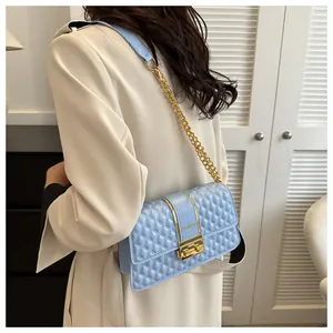 Détail du sac bandoulière matelassé bleu clair avec chaîne dorée et fermoir métal