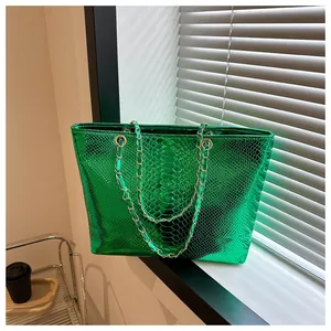 Detail of bright green tote bag with crocodile texture and silver chain straps by window