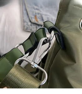 Detailed close-up of the bright silver metal buckle and olive green nylon fabric