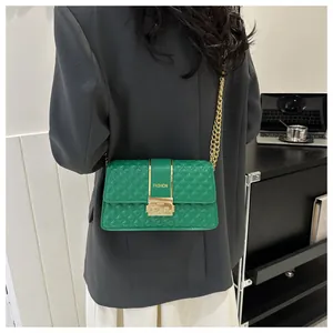 Détail du sac bandoulière matelassé vert avec chaîne dorée et fermoir pivotant en métal