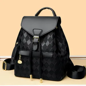 Women black quilted backpack with drawstring closure and gold smiley charm detail