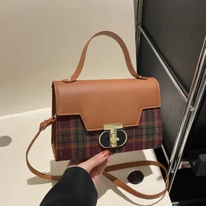 Vintage plaid crossbody handbag with brown leather trim and unique gold metal lock clasp
