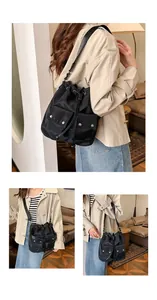 Detail of black drawstring bucket bag with dual front pockets and silver metal buckles
