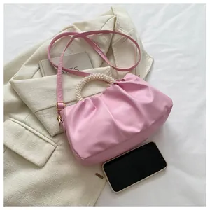 Detail der zartrosa gefalteten Cloud-Tasche mit Perlengriff und PU-Schulterriemen