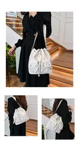 Detail of white nylon bucket bag featuring front utility pockets and silver buckles
