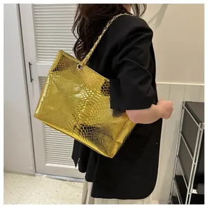 Detail of large gold tote bag with faux snake skin texture and metal chain strap