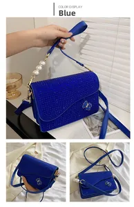 Detail view of blue rhinestone crossbody bag with pearl handle and metal bear charm