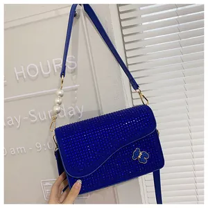 Detail of Klein blue crossbody bag with sparkling rhinestones and pearl buckle