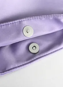 Close-up of lavender nylon fabric with durable magnetic metal clasp detail on handbag