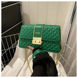 Détail d'un sac bandoulière matelassé vert avec chaîne dorée et fermoir mode en métal