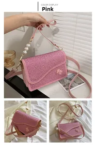 Detail view of pink rhinestone bag with pearl handle and golden bear ornament