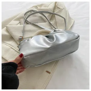 Detailansicht der silbernen Cloud-Tasche mit Perlengriff und Falten-Design aus Leder