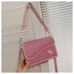 Pink rhinestone crossbody bag with bear logo and pearl shoulder strap detail