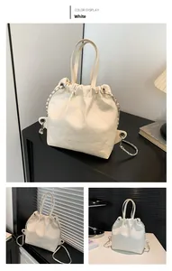 Detail of cream white quilted drawstring bucket bag with silver chain and OH FASHION logo