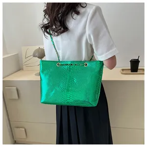 Detail shot of the bright green snakeskin embossed texture with a gold metal chain strap