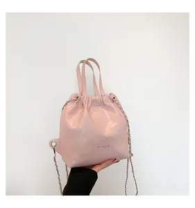 Detailed shot of pink quilted leather bucket bag with silver chain and drawstring closure