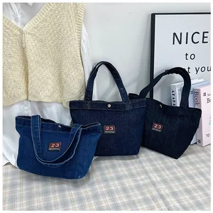 Detailed comparison of three shades of denim tote bags with number 23 embroidery on a table