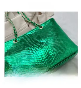 Close-up of bright green metallic snake-patterned faux leather tote bag with chain strap